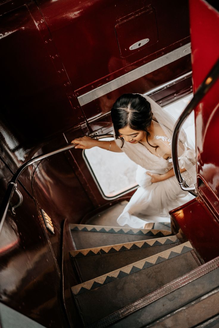 a woman in a white dress is walking down the stairs