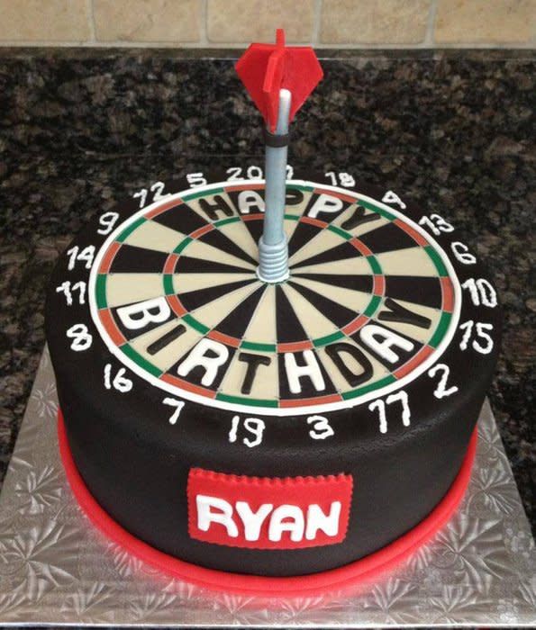 a dart themed birthday cake on a table