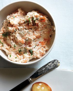 a white bowl filled with food on top of a plate next to a knife and fork