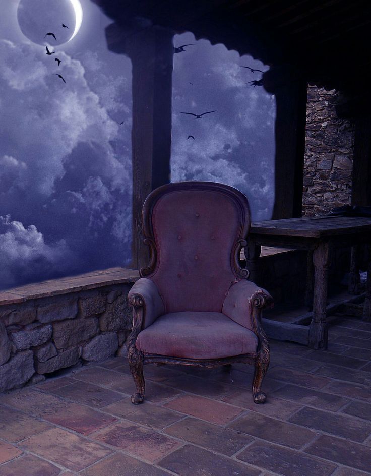 an old chair sitting in front of a wall with clouds and birds flying over it