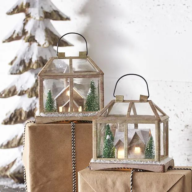 two small glass lanterns sitting next to each other on top of brown paper wrapped presents