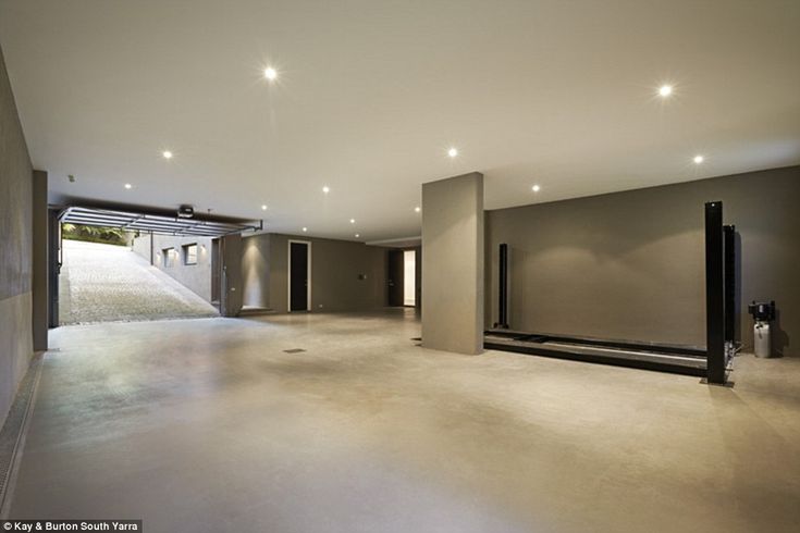 an empty room with lights on the ceiling and large sliding doors leading to another room