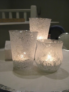 three lit candles sitting on top of a table next to each other in glass cups