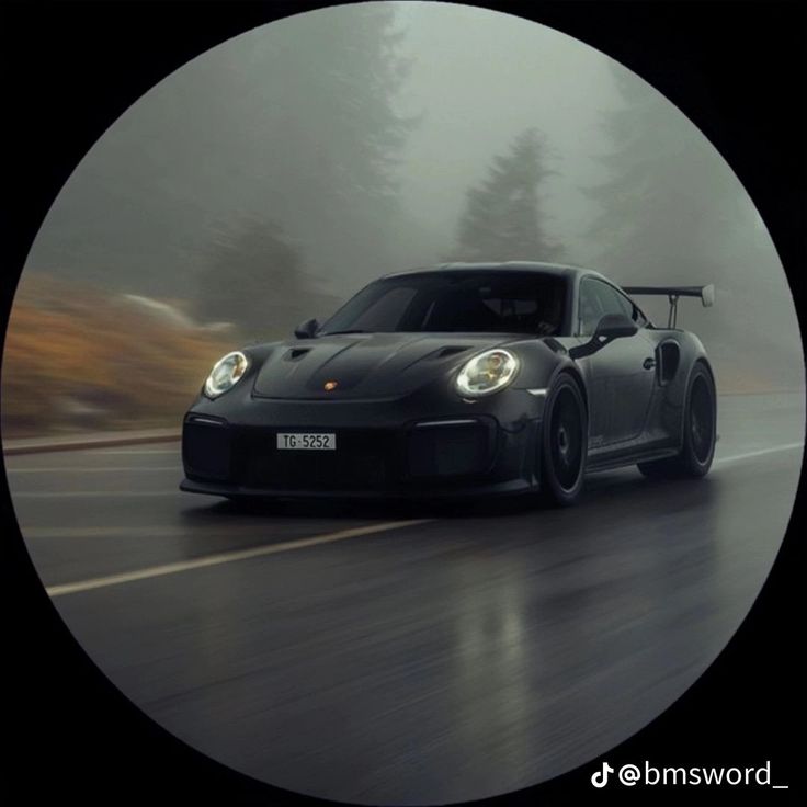 a black sports car driving on a wet road