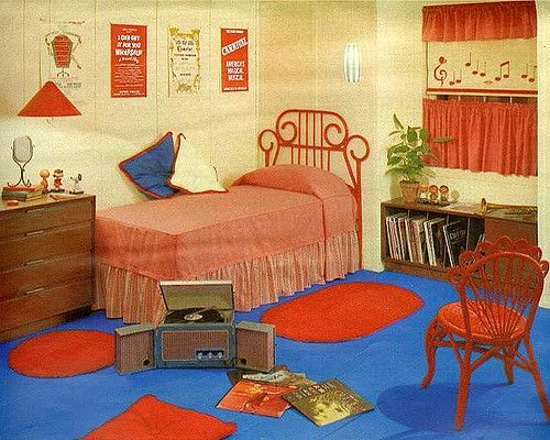 an old photo of a bedroom with red and blue decor on the walls, carpeted flooring and furniture