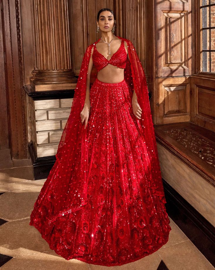 This red lehenga set features all over tonal sequin embroidery in a floral pattern. The ensemble is paired with a strappy blouse with tassels at the waist and a matching net dupatta.From Seema Gujral's A Royal Affair collection. DELIVERY TIMEPlease allow 8-12 weeks for your outfit to arrive. FABRIC DETAILSNet Professional cleaning only. Red Shimmer Lehenga, Indian Lehenga Photoshoot, Sleeveless Bridal Lehenga, Blazer Outfit For Wedding, Red Lengha Bridal, Indian Wedding Outfit Bride, Red Bridal Saree, Red Lehenga Bridal, Shaadi Lehenga