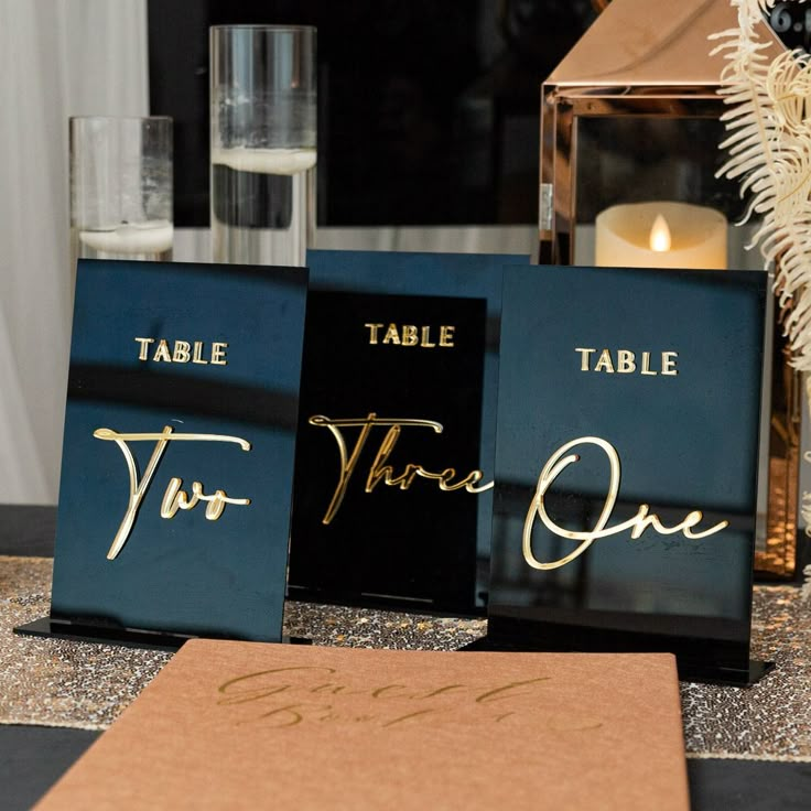 the table name signs are on display for guests to sign their place names in gold ink