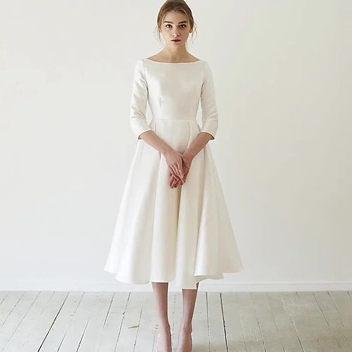 a woman in a white dress standing on a wooden floor