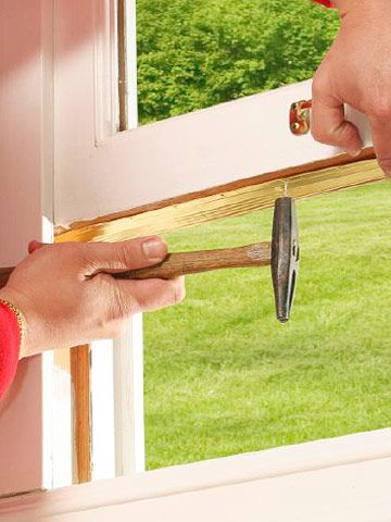 a person is opening the door with a pair of scissors in their hand while another person holds an open window pane