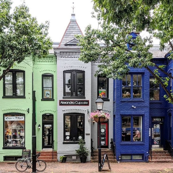 a row of multi - colored buildings with bicycles parked on the sidewalk in front of them