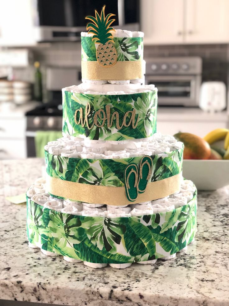 a three tiered cake sitting on top of a counter next to a bowl of fruit