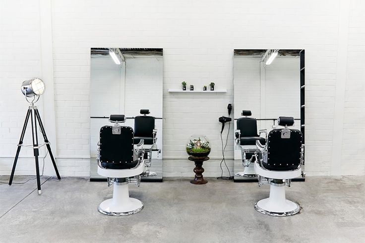 a barber shop with chairs and hair dryers in front of it's mirrors