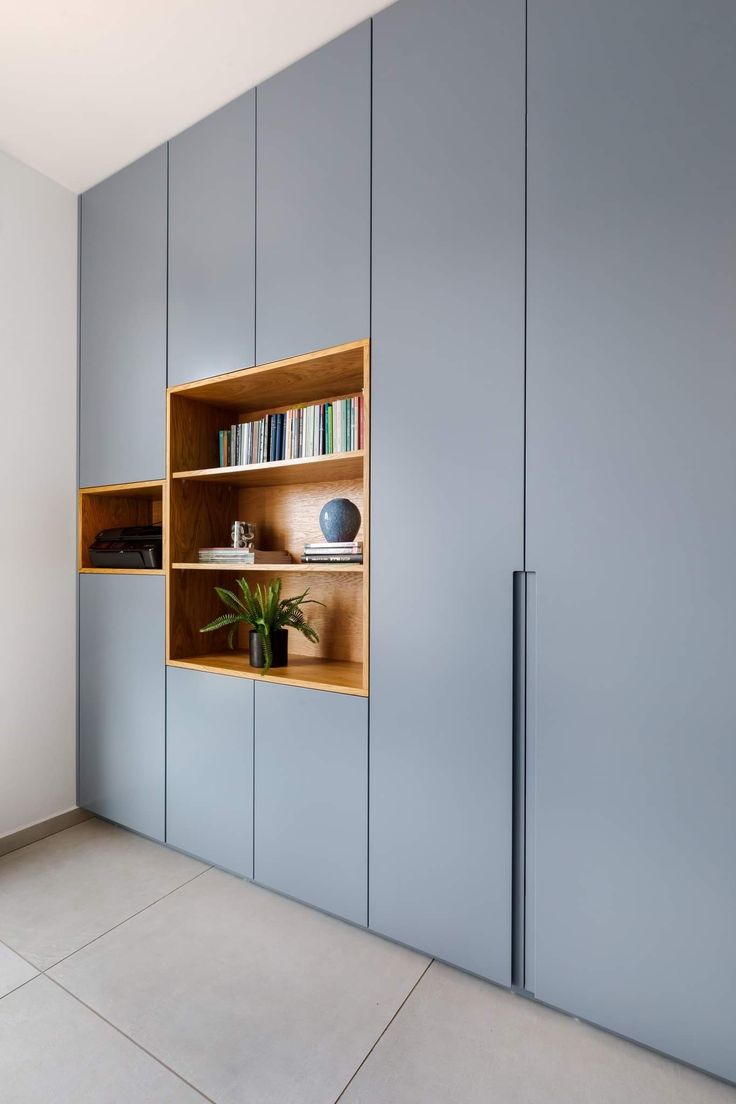 an empty room with some bookshelves and shelves on the wall next to each other