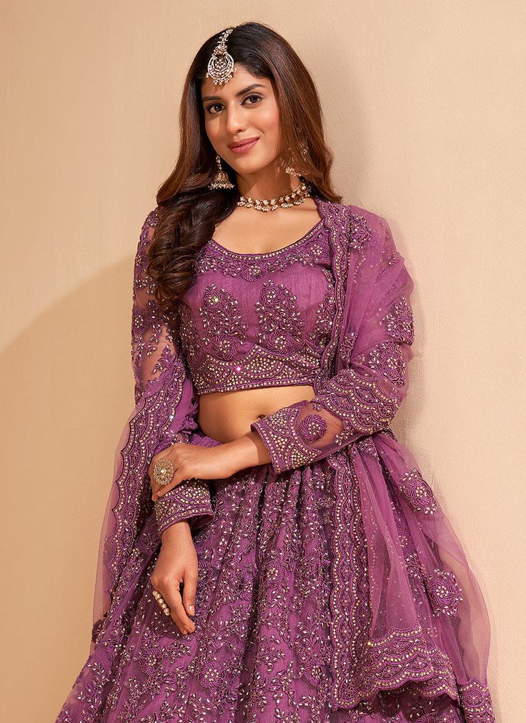 Purple Crystal Embroidered Wedding Lehenga Choli Shop Eid Outfits & Dress. Free International Shipping. best pick as an indian wear for festivals or wedding event. This elegant set has a very pretty thread embroidery detailed with zari and pearl work on canned net lehenga with satin lining paired with equally embellished matching net and satin choli and ethnic motifs embroidered net dupatta. Team this beautiful attire with classic pair of heels and golden jewellery to look like a diva. This set Embroidered Lehenga For Wedding Eid, Embroidered Lehenga For Wedding Eid Celebration, Embroidered Lehenga For Wedding And Eid, Wedding Lehenga With Resham Embroidery In Chinon, Embroidered Lehenga For Wedding On Eid, Embroidered Lehenga For Wedding During Eid, Festive Kundan Sets For Wedding, Bollywood Wedding Sets With Dabka Work, Wedding Sets In Chinon With Zari Work