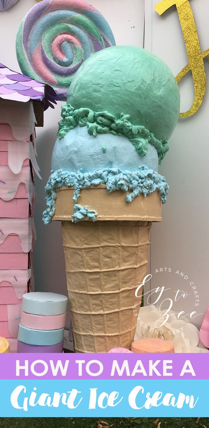 an ice cream cone with blue and green icing on it in front of a sign that says how to make a giant ice cream cone