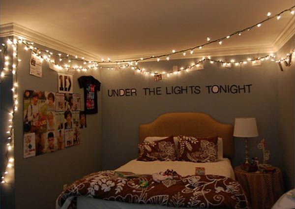 a bed room with a neatly made bed and string lights