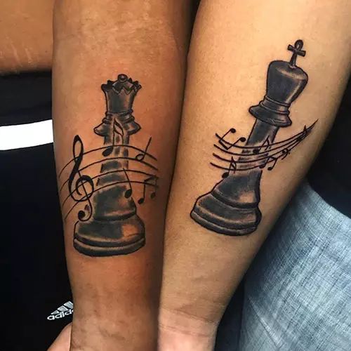 two people with matching tattoos on their arms, one has a chess piece and the other has music notes