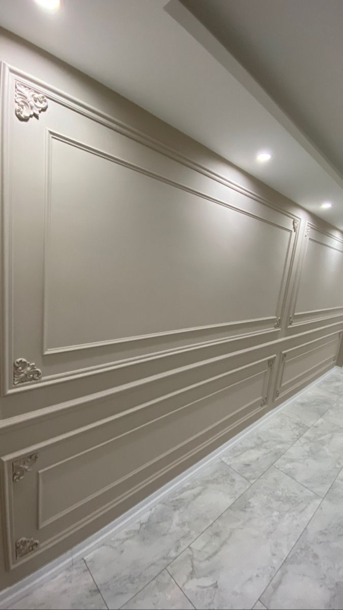 an empty room with white marble floors and wall paneling on the walls is pictured in this image