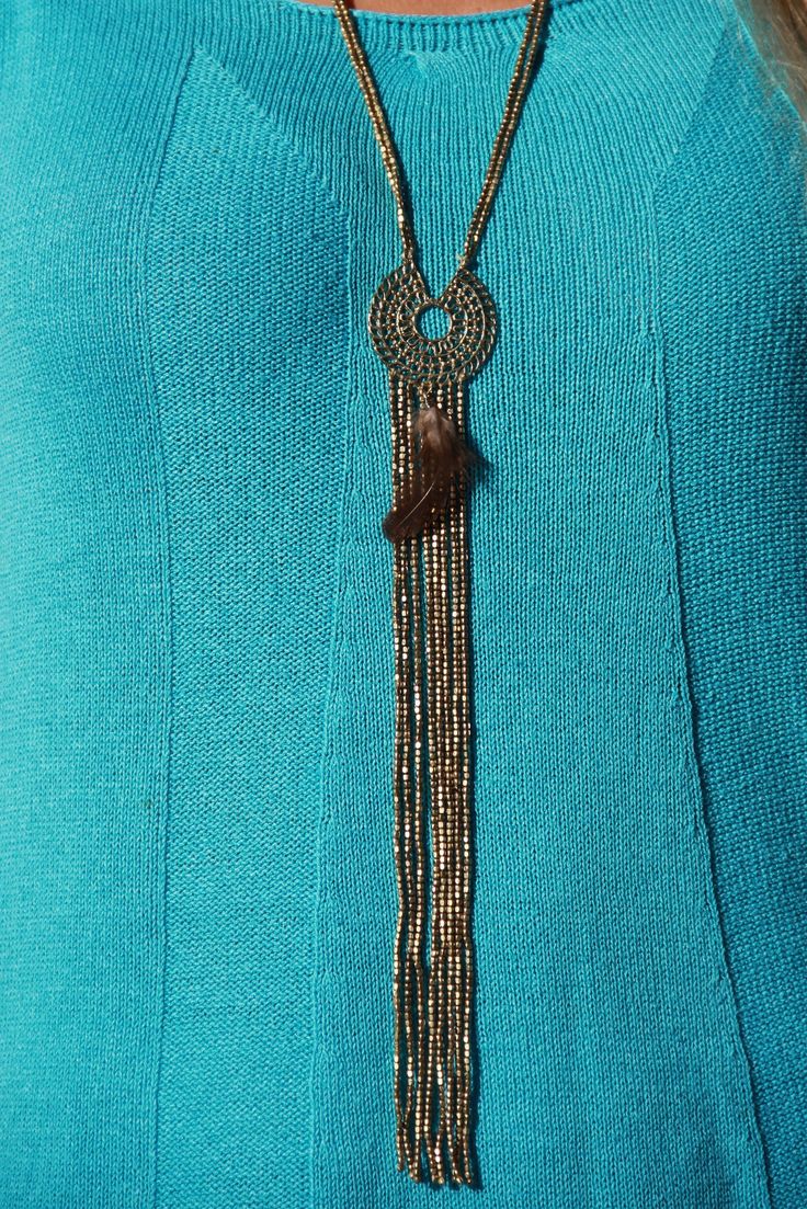 A long golden vintage looking necklace consisting of two strings of small round brass beads which are connected to a round brass pendent with a feather connected to it. At the bottom of the pendent there is a long tassel which is made of 8 strings of small round brass beads. --------------------------------------- FEATURES Size: 60 cm Materials used: Round brass beads / Brass pendent / Feather --------------------------------------- Check out other necklaces by Moksha Jewelry: http://etsy.me/2qR Gold Beaded Multi-strand Lariat Necklace, Bohemian Multi-strand Chain Necklace, Gold Tassel Necklaces For Festival, Bohemian Multi-strand Beaded Chain Necklace, Bohemian Beaded Metal Long Necklace, Gold Bohemian Beaded Metal Necklace, Gold Tassel Necklace For Festivals, Bohemian Gold Beaded Metal Necklace, Bohemian Gold Long Necklace With Round Beads