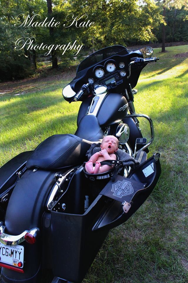 a black motorcycle parked on top of a lush green field