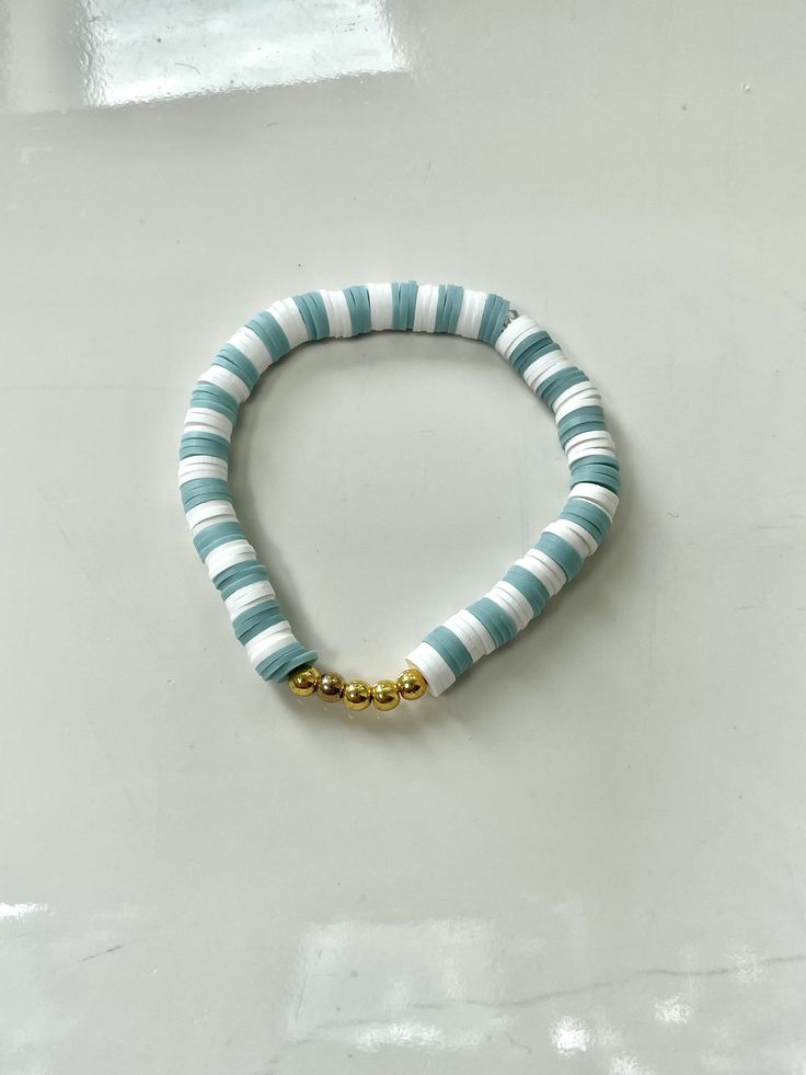 This bracelet is made out of stretchy string and clay beads. It's such a coastal and beachy bracelet, especially for the boardwalk! All orders will recieve 2 stickers and a ring for free. White Adjustable Stretch Bracelet With Beachy Style, Adjustable White Stretch Bracelet With Beachy Style, White Adjustable Beachy Stretch Bracelet, Beachy White Round Bead Bracelets, Beachy White Bracelets With Round Beads, Green Stackable Stretch Bracelet For Beach, Heishi Beaded Bracelets For Everyday Summer Wear, Beachy White Stretch Bracelet For Vacation, White Beachy Stretch Bracelet For Summer