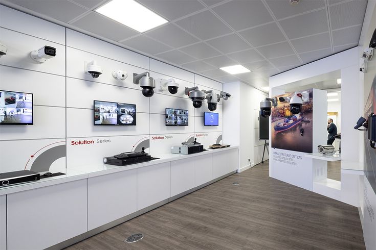 an office with white walls and multiple cameras on the wall, along with other equipment