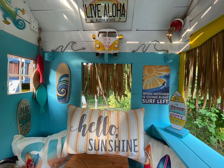 the inside of a bus with surfboards hanging from the ceiling and signs on the walls