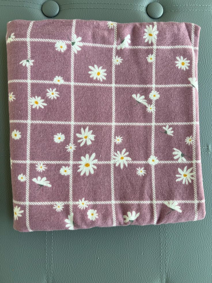 a pink and white flowered blanket hanging on a wall