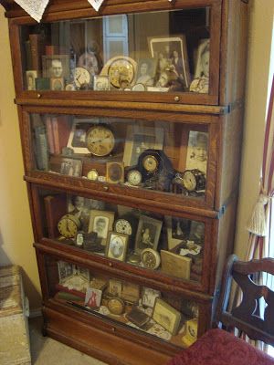 an old wooden bookcase with many clocks on it