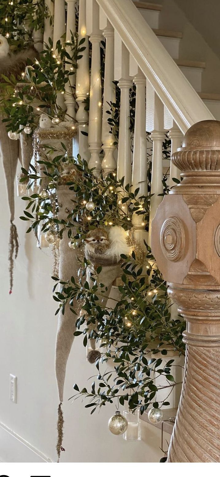 the stairs are decorated with candles and greenery for christmas time as well as garland