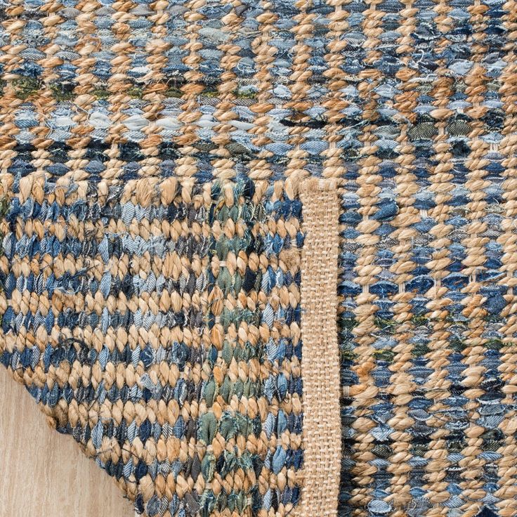 a close up view of a blue and brown rug with a wooden floor mat on it