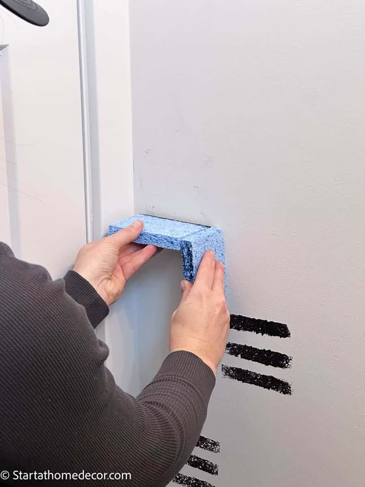 a person is cleaning the wall with a sponge