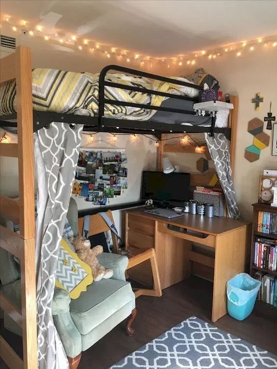 a loft bed with a desk underneath it and lights strung from the ceiling above it