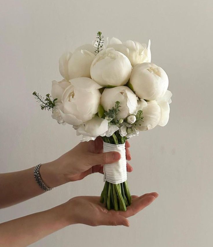 a person holding a bouquet of white flowers