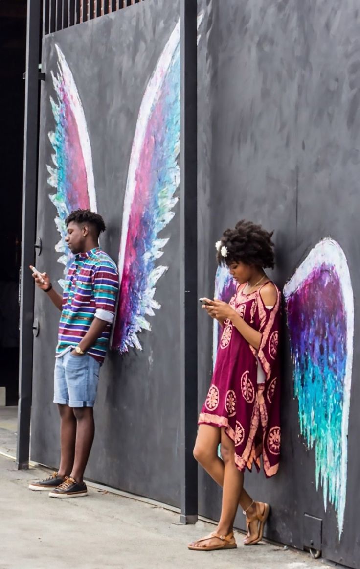 two children standing next to each other near a wall with wings painted on it and the caption reads, ruined childhood