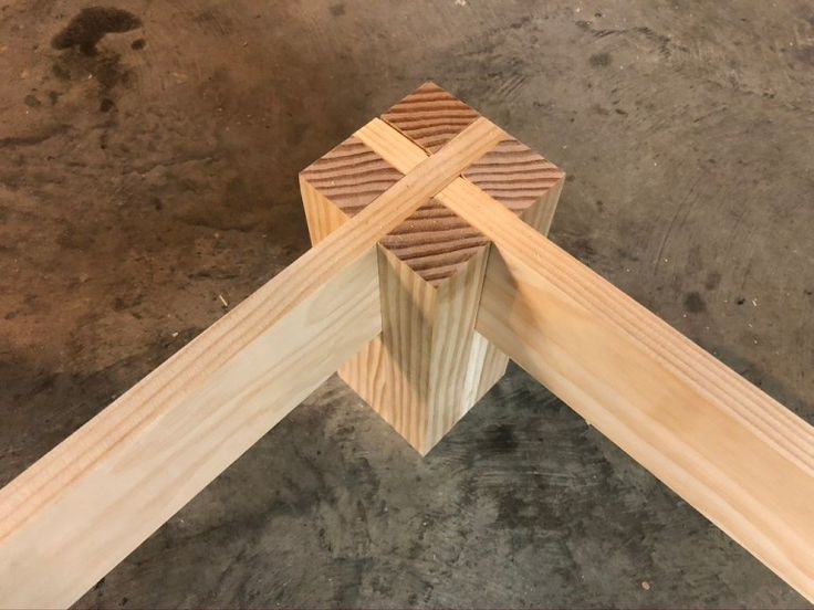 a wooden cross sitting on top of a cement floor