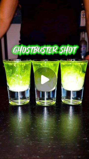 three shot glasses sitting on top of a table with green liquid in them and the words ghostbuster shot