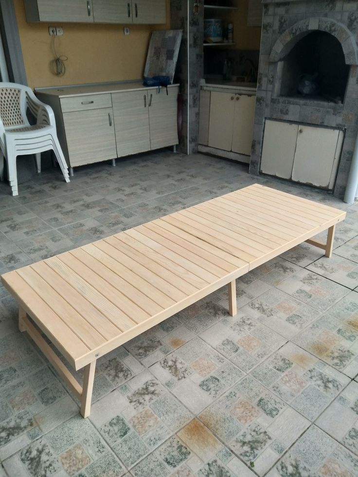 a wooden table sitting on top of a tile floor next to a kitchen area with an oven