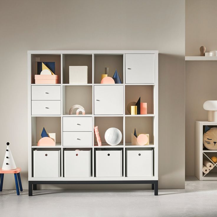 a white bookcase filled with lots of books next to a shelf full of boxes