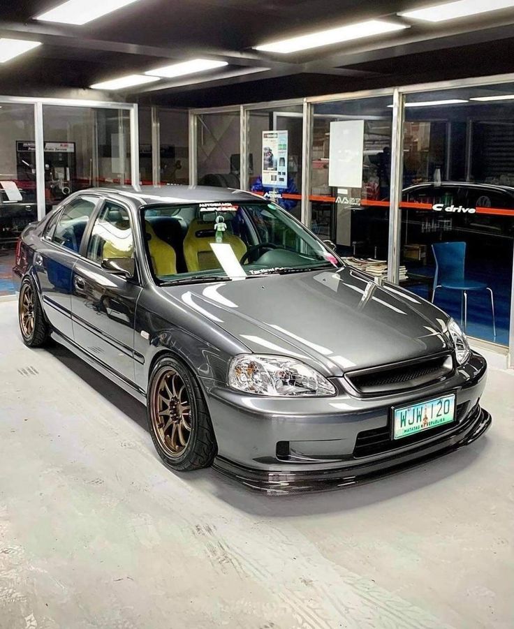 a silver car parked in a garage next to other cars