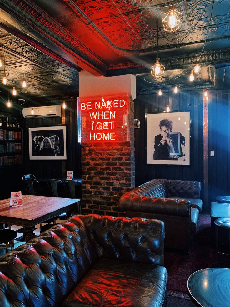 a dimly lit room with leather couches and tables