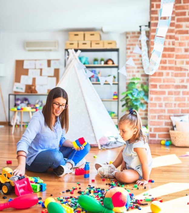 a woman and child playing with toys on the floor