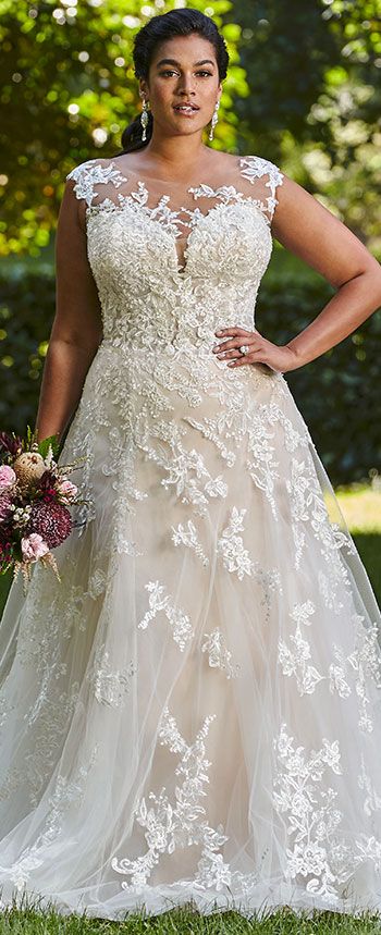 a woman in a wedding dress posing for the camera with her hands on her hips