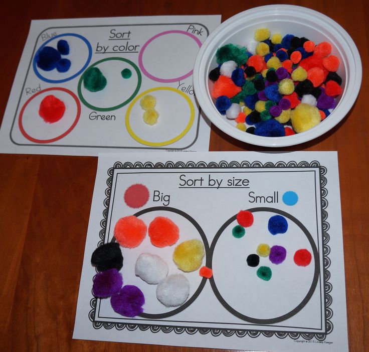 two paper plates with different colored pom poms on them