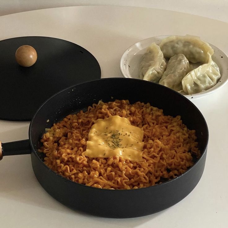 some food is sitting in a pan on a white counter top next to other foods