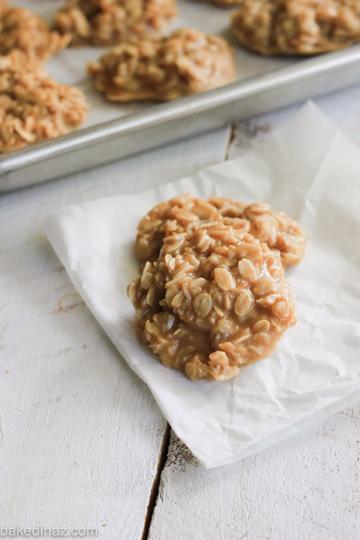 an oatmeal cookie sitting on top of a piece of parchment paper next to some cookies