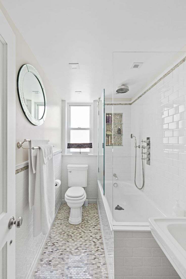 a white bathroom with tile flooring and walls, along with a walk in shower