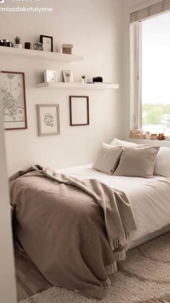 a bed sitting in a bedroom next to a window