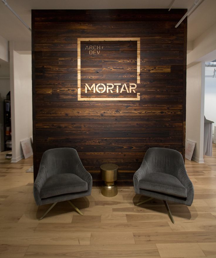 two chairs sitting in front of a wooden wall with the word mortar on it