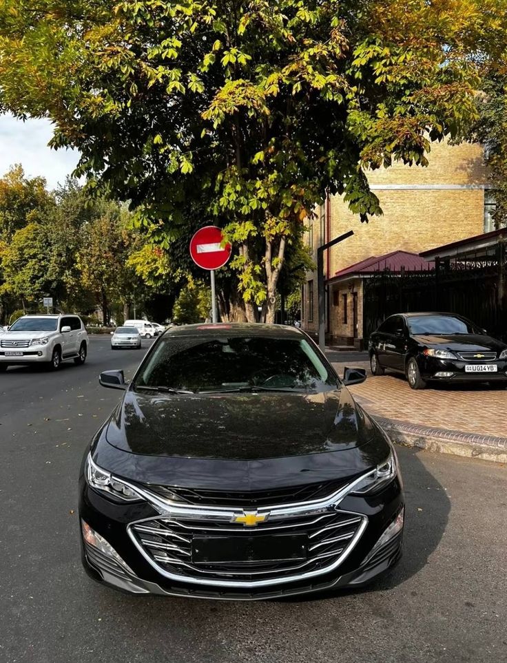 a black car parked on the side of a road